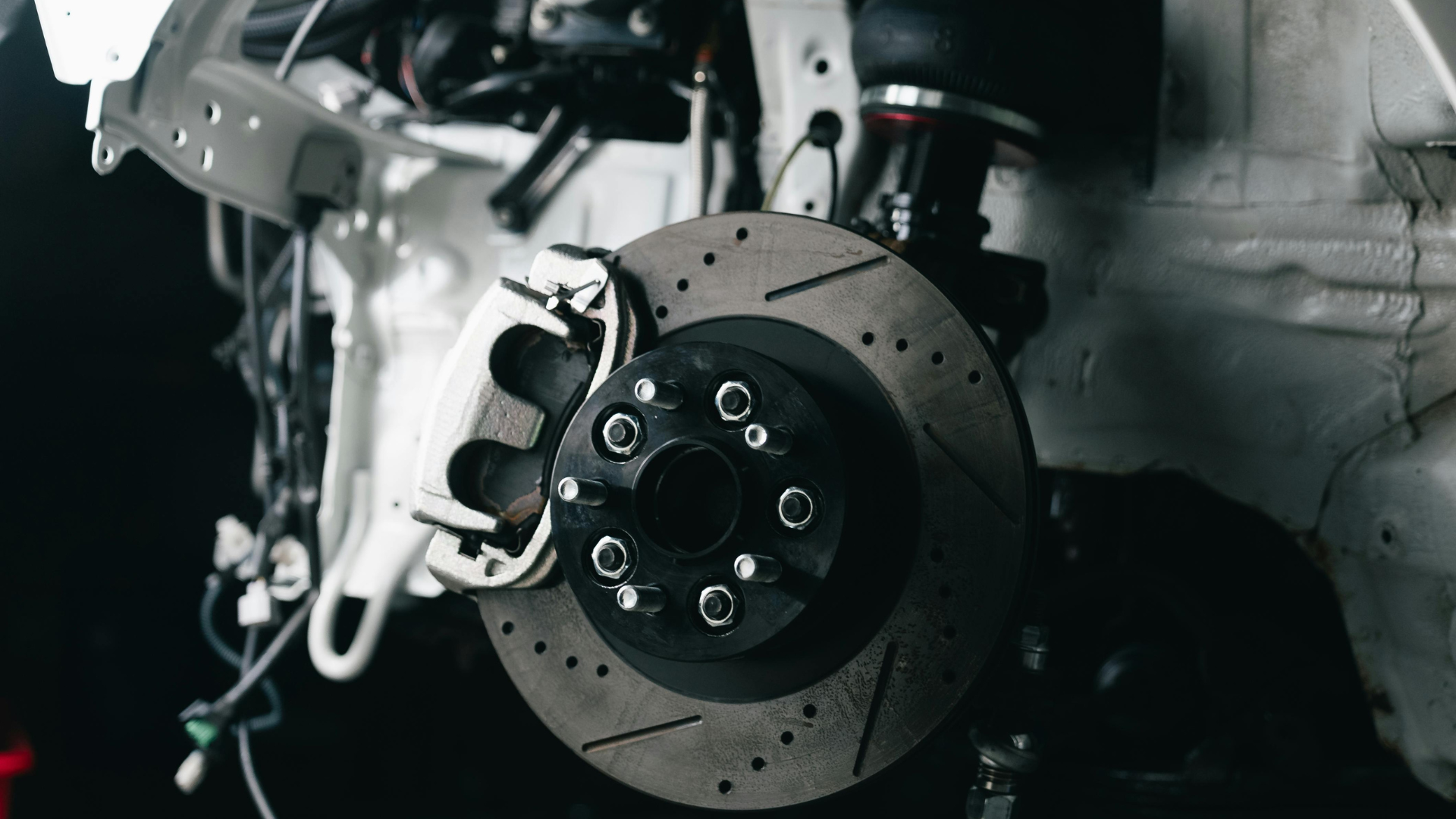 Drilled and slotted brake disc with caliper on a car hub