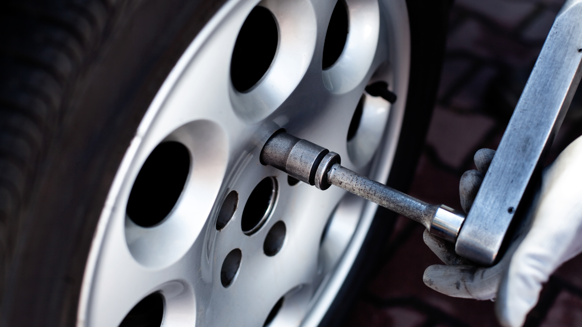 Specialist socket engaged on a locking wheel nut on a car alloy