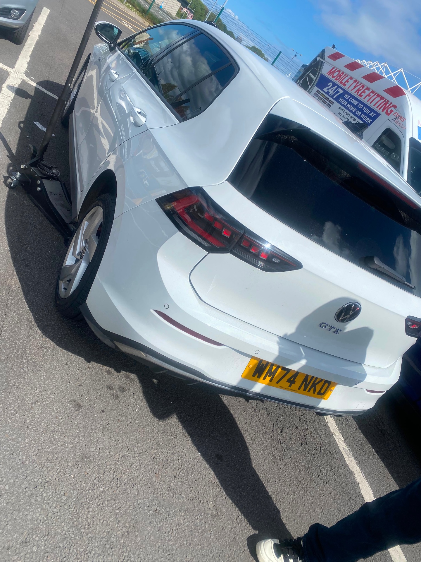 Mobile tyre fitting on a Volkswagen Golf GTE at a commercial parking area