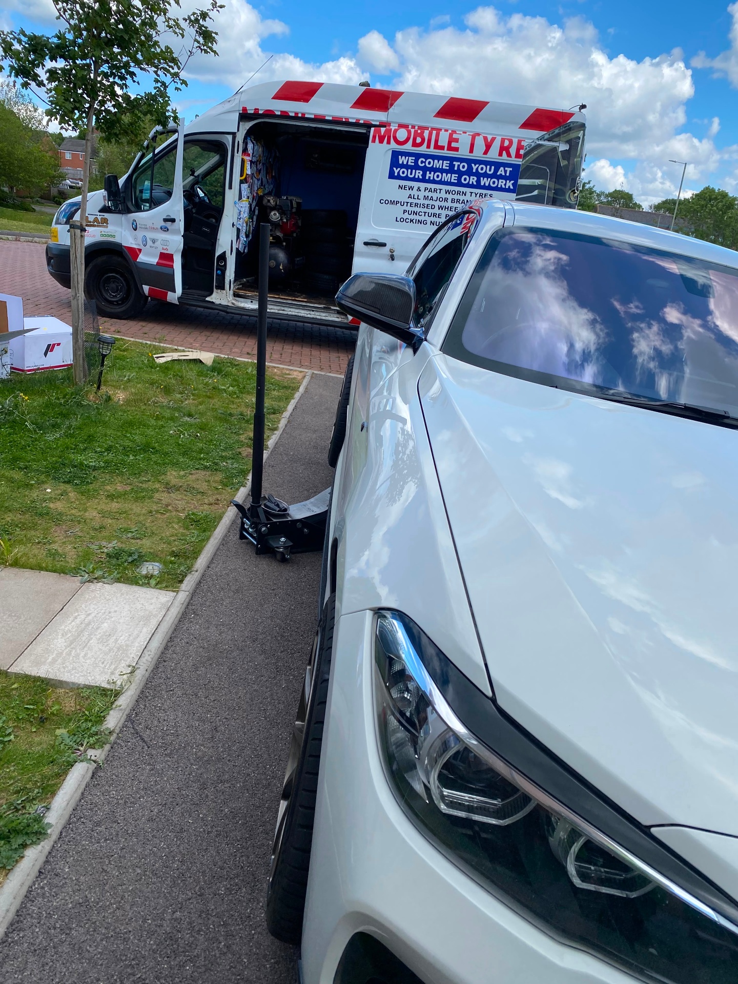 Mobile tyre fitting on a driveway — BMW with wheel removed